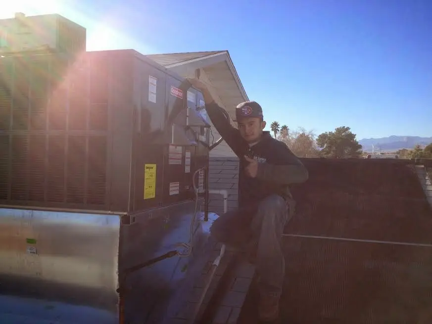 HVAC technician performing Air Duct Cleaning on a rooftop unit in Southampton